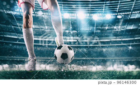 Football scene at night match with player ready to shoot the ball Football scene at night match with player ready to shoot the ball 96146300