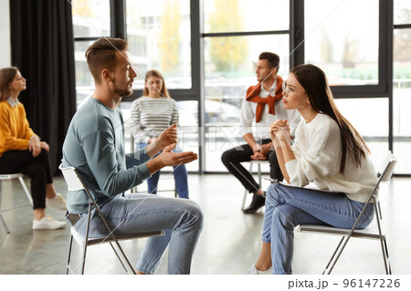 Psychotherapist working with patient in group therapy session indoors 96147226