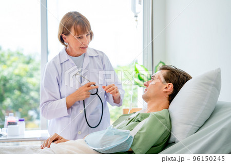 Caucasian woman doctor talk and discuss with young patient man who have arm problem 96150245