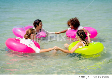 Group of teen girls float and swim in the sea and form like circle together and look fun to play Group of teen girls float and swim in the sea and form like circle together and look fun to play 96154960