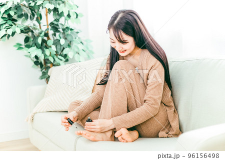 家のソファで足の爪を切る日本人女性 96156498