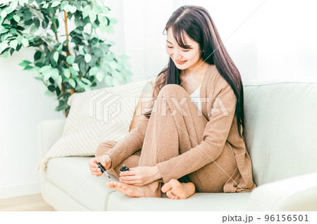 家のソファで足の爪を切る日本人女性 家のソファで足の爪を切る日本人女性 96156501