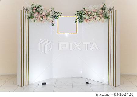 White photo zone with delicate flowers for the hero of the day in the cafe 96162420