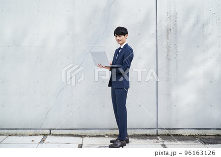 ノートパソコンを手に持つ男性 96163126