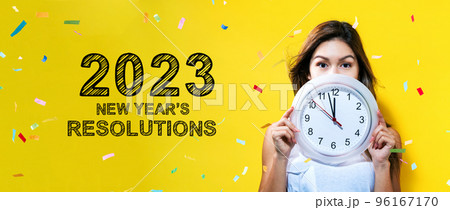 2023 New Years Resolutions with young woman holding a clock 2023 New Years Resolutions with young woman holding a clock 96167170