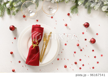 Christmas table setting with elegant red decorations on white table. Christmas table setting with elegant red decorations on white table. 96167541