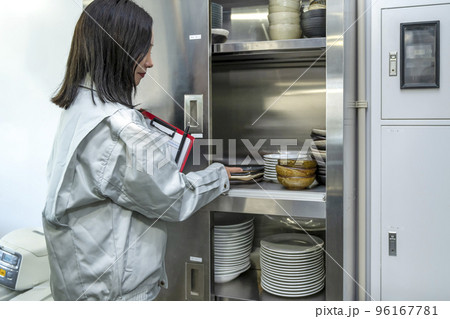 厨房を確認する若い女性 棚と食器 厨房を確認する若い女性 棚と食器 96167781