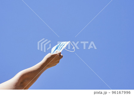 someone's hand holding a kite in the air with a string attached to it, against a blue sky background 96167996