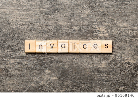 INVOICES word written on wood block. INVOICES text on cement table for your desing, concept 96169146