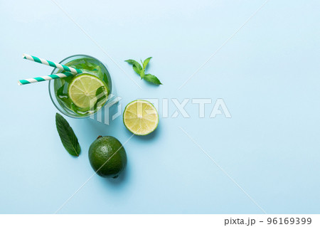 Caipirinha, Mojito cocktail, vodka or soda drink with lime, mint and straw on table background. Refreshing beverage with mint and lime in glass top view flat lay Caipirinha, Mojito cocktail, vodka or soda drink with lime, mint and straw on table background. Refreshing beverage with mint and lime in glass top view flat lay 96169399