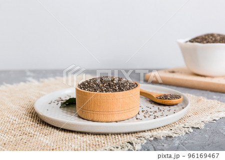 Chia seeds in bowl and spoon on colored background. Healthy Salvia hispanica in small bowl. Healthy superfood Chia seeds in bowl and spoon on colored background. Healthy Salvia hispanica in small bowl. Healthy superfood 96169467