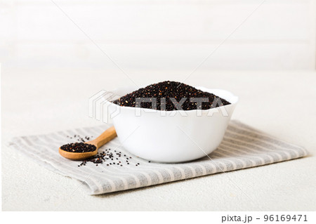 quinoa seeds in bowl and spoon on colored background. Healthy kinwa in small bowl. Healthy superfood 96169471