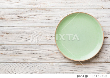 Top view of empty green plate on wooden background. Empty space for your design 96169706