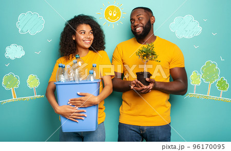 Happy couple hold a plastic container with bottles and a small tree over a light blue color. Concept of ecology, conservation, recycling and sustainability 96170095