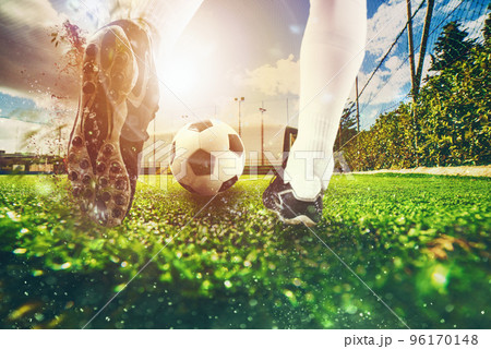 Close up scene at soccer field with a soccer shoe hitting the ball during training Close up scene at soccer field with a soccer shoe hitting the ball during training 96170148