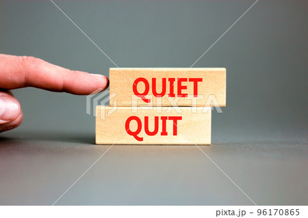 Quiet quit symbol. Concept words Quiet quit on wooden blocks. Beautiful grey table grey background. Businessman hand. Business and quiet quit concept. Copy space. 96170865