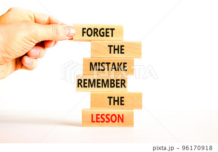 Lesson from mistake symbol. Concept words Forget the mistake remember the lesson on wooden blocks on a beautiful white table white background. Businessman hand. Business lesson from mistake concept. Lesson from mistake symbol. Concept words Forget the mistake remember the lesson on wooden blocks on a beautiful white table white background. Businessman hand. Business lesson from mistake concept. 96170918