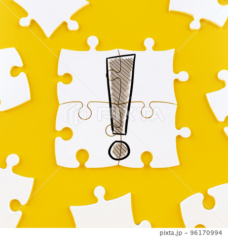 Puzzle tiles on a yellow background forming an exclamation point 96170994