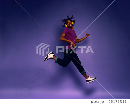 Boy with yellow headset listens to music and dances. emotional and energetic expression 96171311
