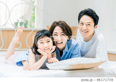 ベットに入る若い仲良し家族イメージ 96171739