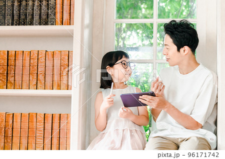 勉強する小学生の女の子を見守る父親 96171742