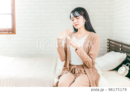 高熱が出て体温計で体温を測る風邪の女性 96175179