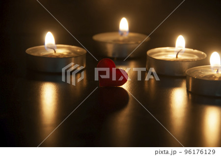 Red heart shape on dark candlelight background with customizable space for text or ideas. Red heart shape on dark candlelight background with customizable space for text or ideas. 96176129