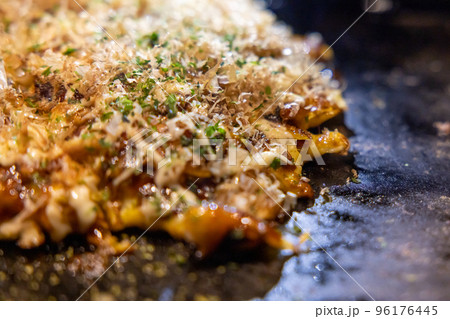 鉄板の上で焼かれるお好み焼き 96176445
