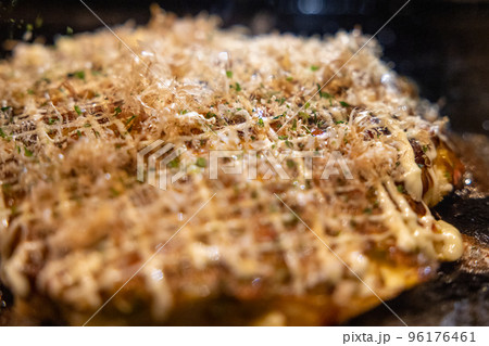 鉄板の上で焼かれるお好み焼き 96176461