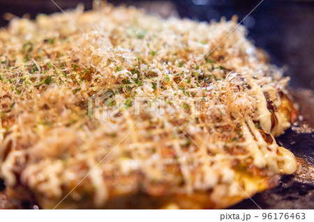 鉄板の上で焼かれるお好み焼き 96176463
