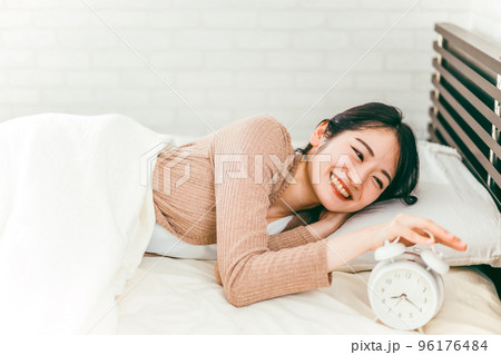 朝ベッドルームでスッキリと笑顔で起床する日本人女性 朝ベッドルームでスッキリと笑顔で起床する日本人女性 96176484