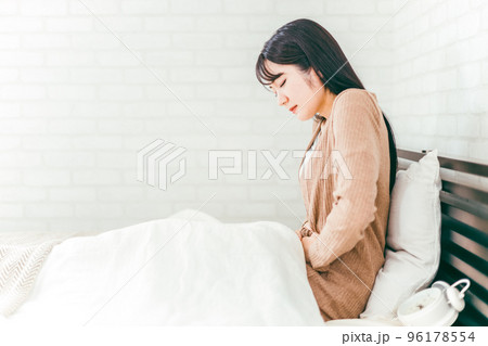 ベッドルームで腹痛・生理痛に悩む日本人女性 ベッドルームで腹痛・生理痛に悩む日本人女性 96178554