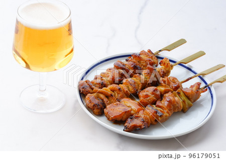 炭火焼の焼き鳥（タレ）をつまみにビールを飲む 96179051
