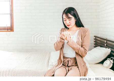 ベッドで手荒れ・湿疹に悩む日本人女性 96179494