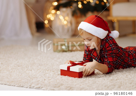 The girl lies on the floor with a gift in a box The girl lies on the floor with a gift in a box 96180146