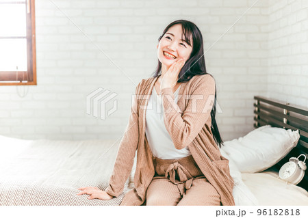 ベッドルームでスキンケアする笑顔の日本人女性 ベッドルームでスキンケアする笑顔の日本人女性 96182818