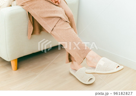 床暖房の部屋でソファに座るスリッパを履いた女性の足 96182827