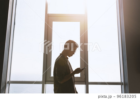 Businessman works with the phone in office. 96183205