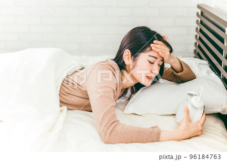 寝坊して目覚まし時計で起きる女性(遅刻) 寝坊して目覚まし時計で起きる女性(遅刻) 96184763