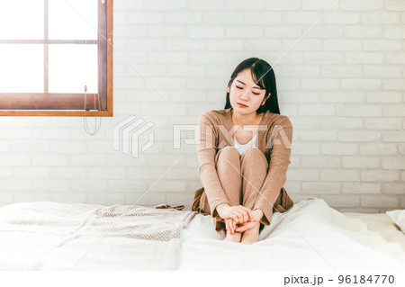 ベッドルームで憂鬱・退屈・トラブルで悩むパジャマ姿の日本人女性 96184770