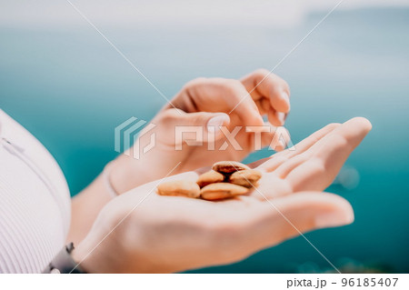 Young milky almond nuts in womans hand. A young caucasian woman 96185407