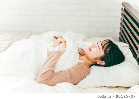 ベッドで睡眠中に笑う日本人女性（笑顔） 96185707