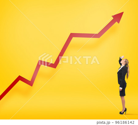 Businesswoman watches her company statistic grow up. Yellow background 96186142