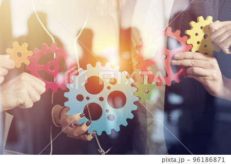 Business team connect pieces of gears. Teamwork, partnership and integration concept. double exposure 96186871