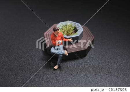 a mini of figure sit on the park bench a mini of figure sit on the park bench 96187398