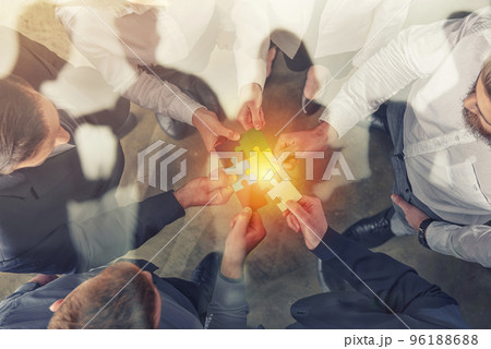 Business people join puzzle pieces. Concept of teamwork and partnership. double exposure. 96188688