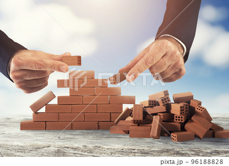 Businessman puts a brick to build a wall. Concept of new business, partnership, integration and startup 96188828