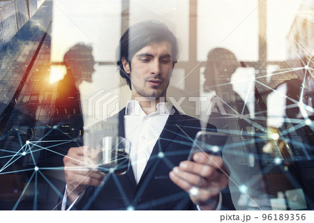 Businessman works with his smartphone in office. double exposure. 96189356