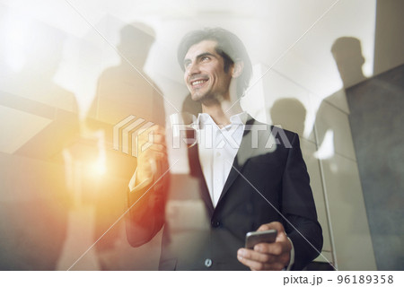 Businessman works with his smartphone in office. double exposure. 96189358