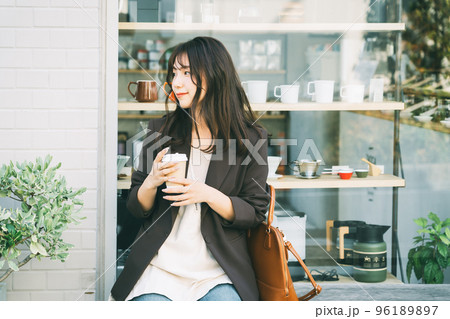 屋外でコーヒーを飲む女性 96189897